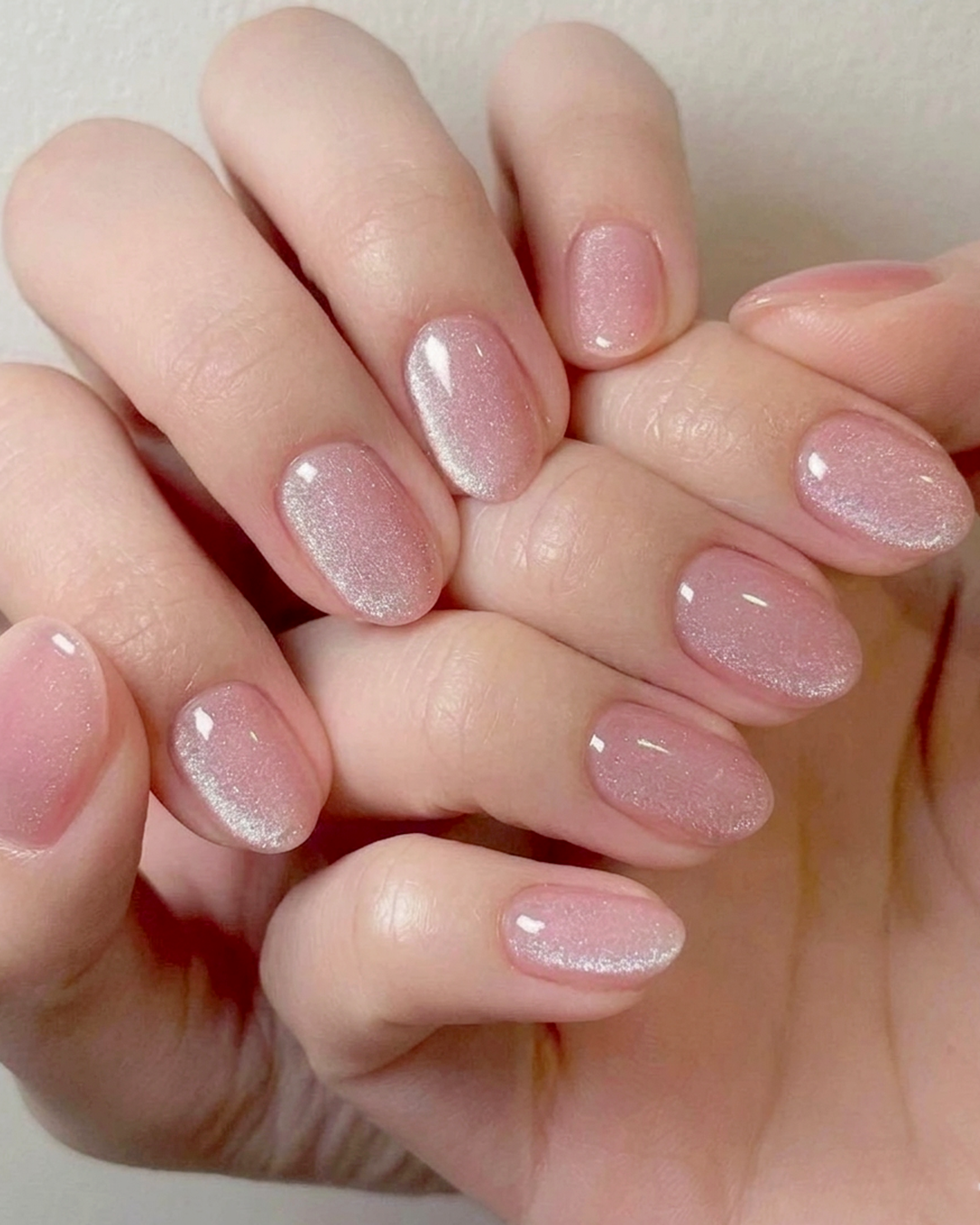 Soft pink glitter short nails with almond shape and subtle shimmer