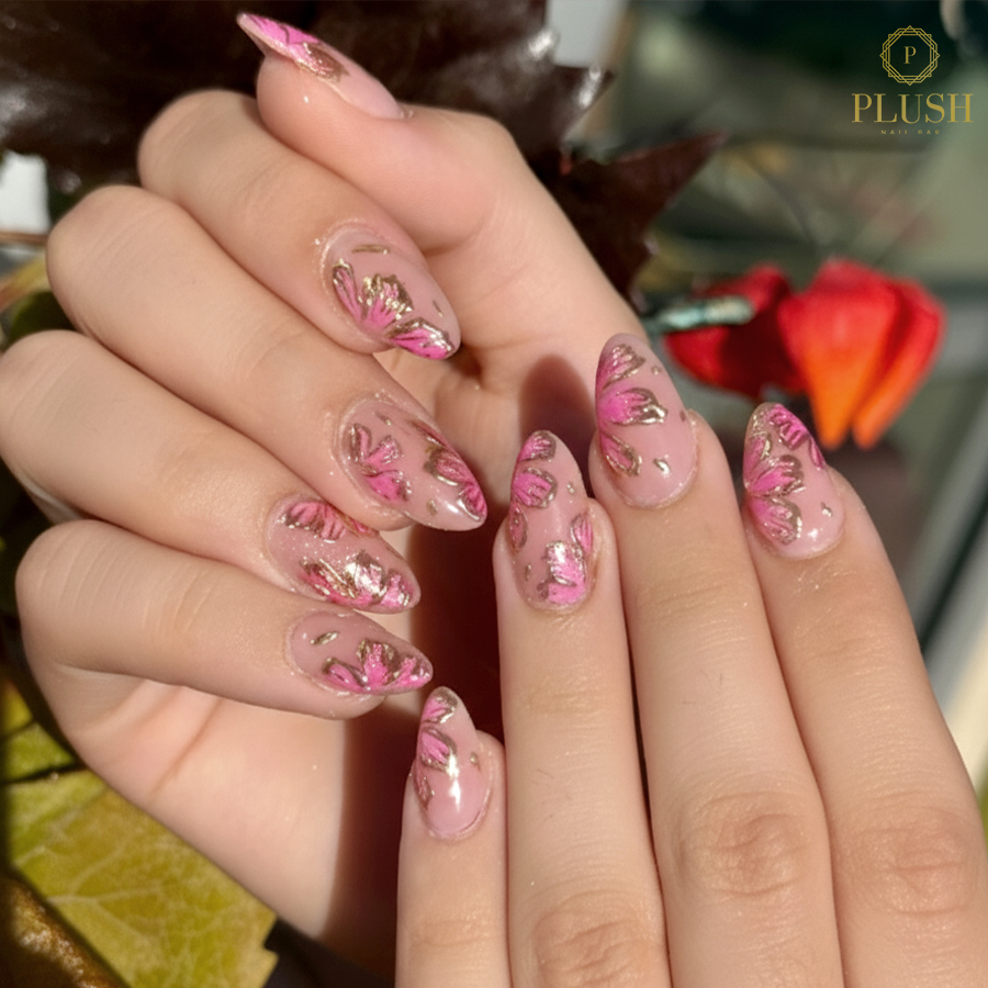 Soft pink almond nails with hand-painted fall florals and metallic gold detailing