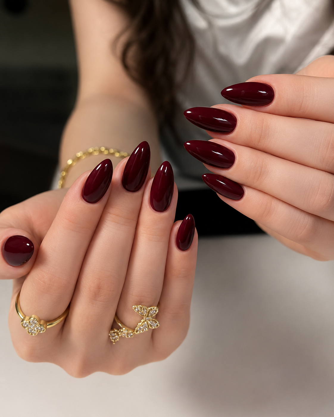 Classic solid glossy vampy red almond nails in a deep burgundy shade with a high-shine glass finish.