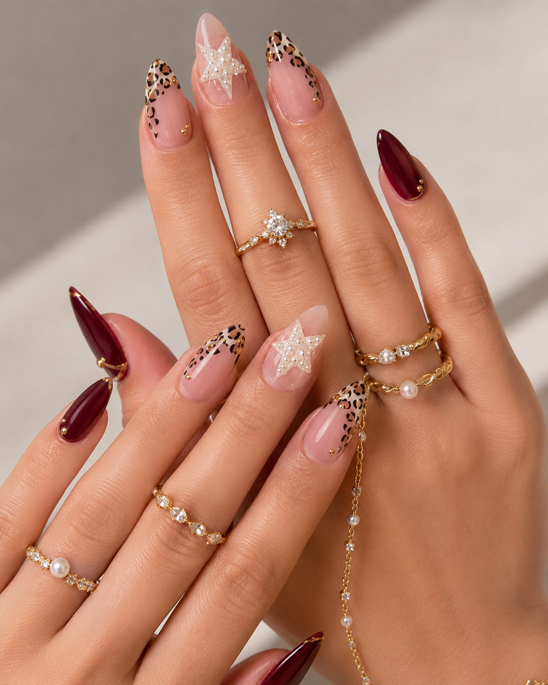 Bold Homecoming nail ideas combining animal print tips, 3D star charms, and rich wine tones.