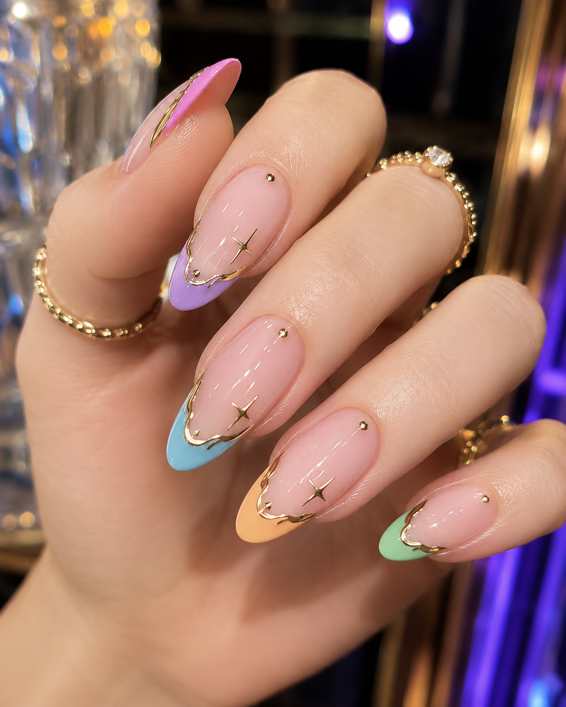 Colorful pastel french nail with gold star details and metallic accents