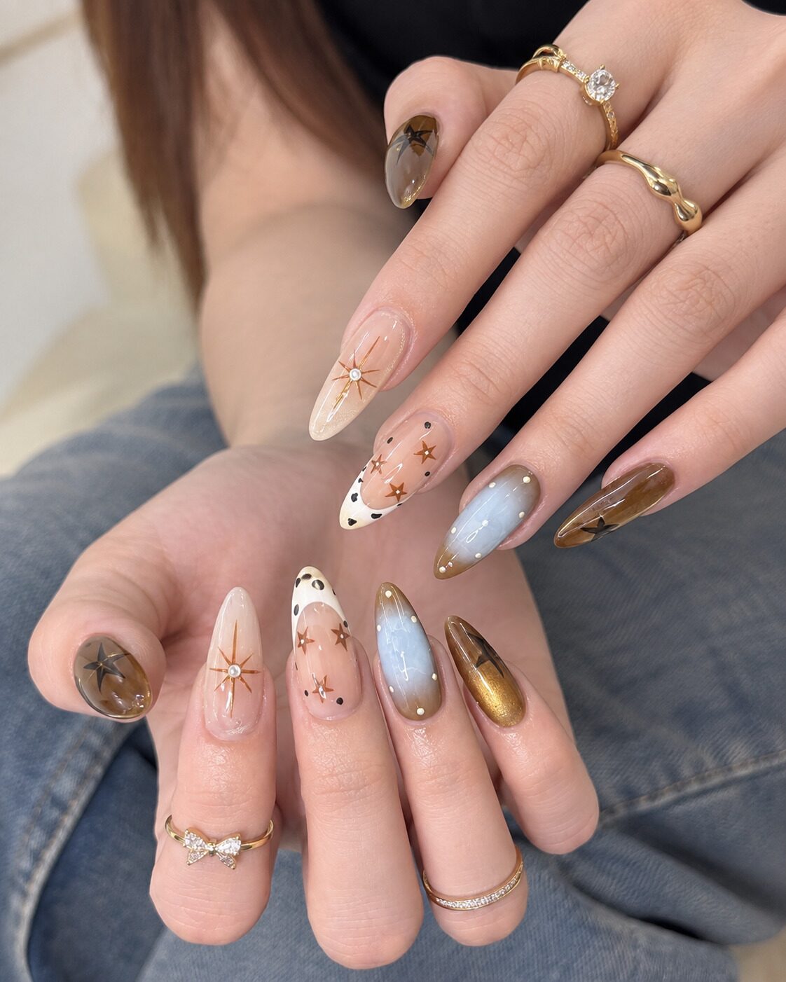 Celestial autumn nail ideas with gold stars smokey quartz effect and pearl studs