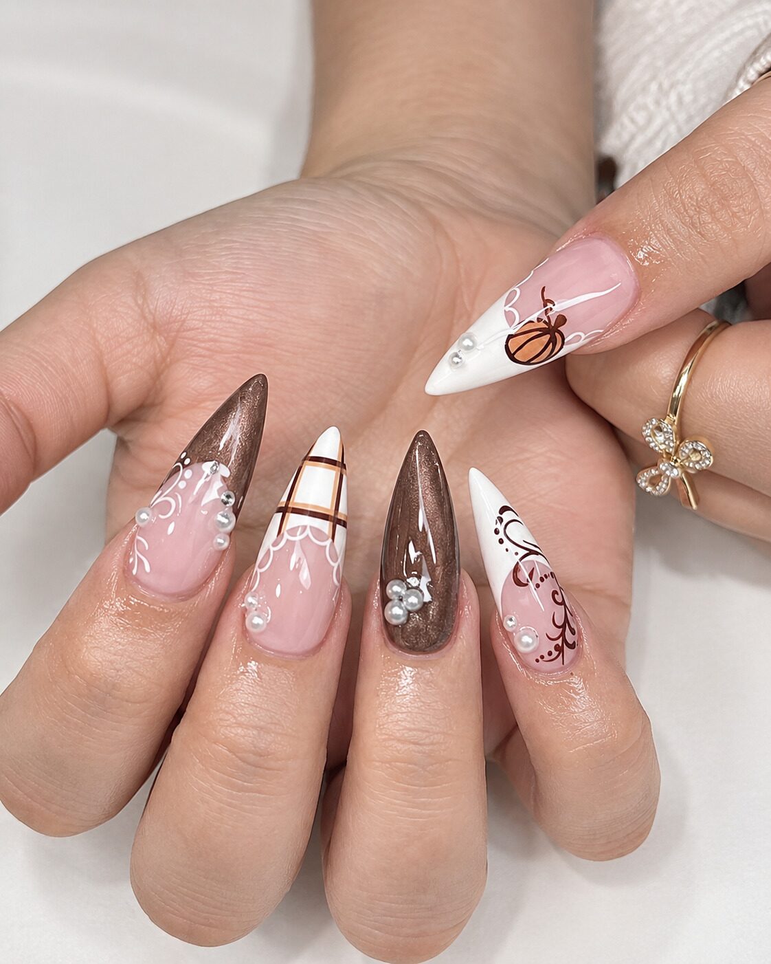 Luxe fall stiletto nails with pearl embellishments chocolate brown tips and lace details