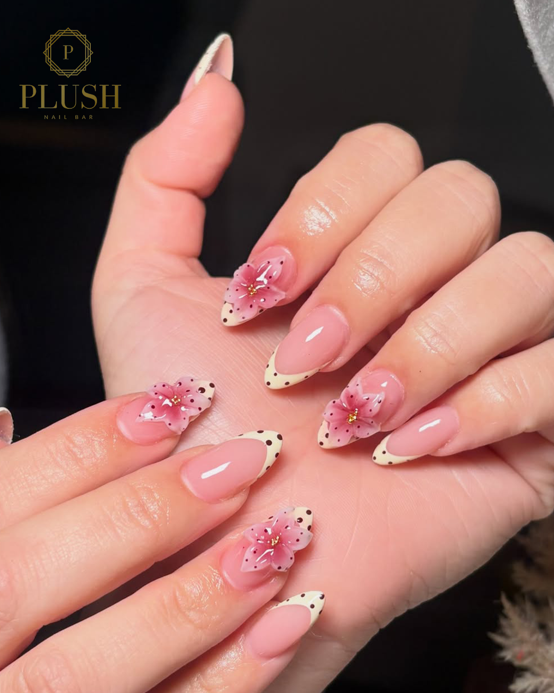 Spring Break Bliss: 4 Stunning Floral Nail Ideas That Will Instantly Elevate Your Vacation Look 1 Soft pink almond-shaped Spring break nails with 3D floral accents, cream French tips, and delicate polka dot details.