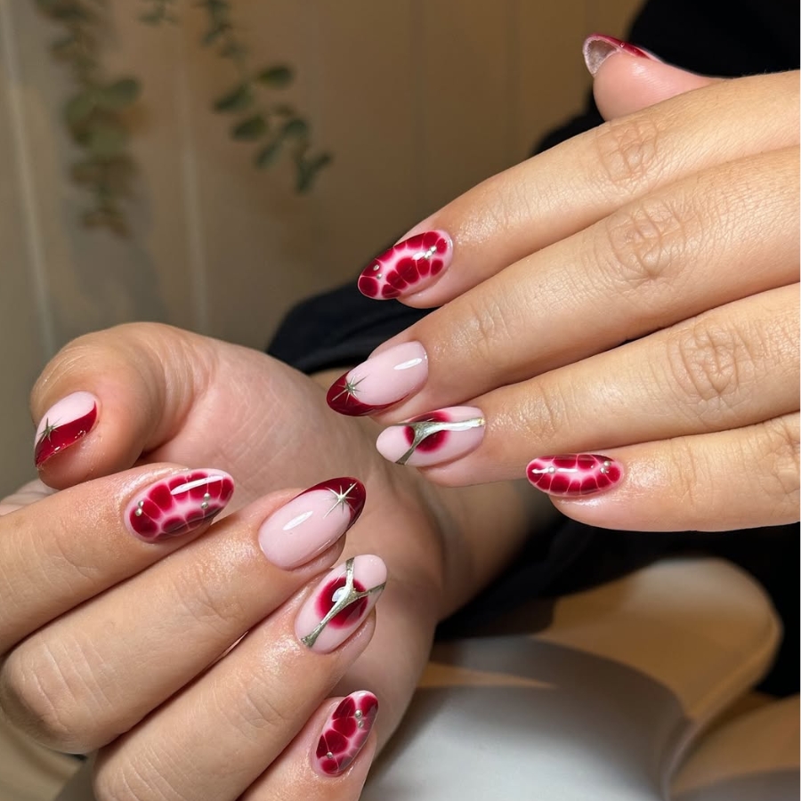 Burgundy manicure with soft nude base and blooming floral petal design for fall.