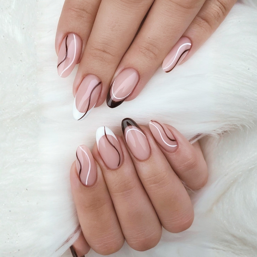 Trendy French manicure idea featuring white and brown tips with wavy abstract lines on a neutral base.
