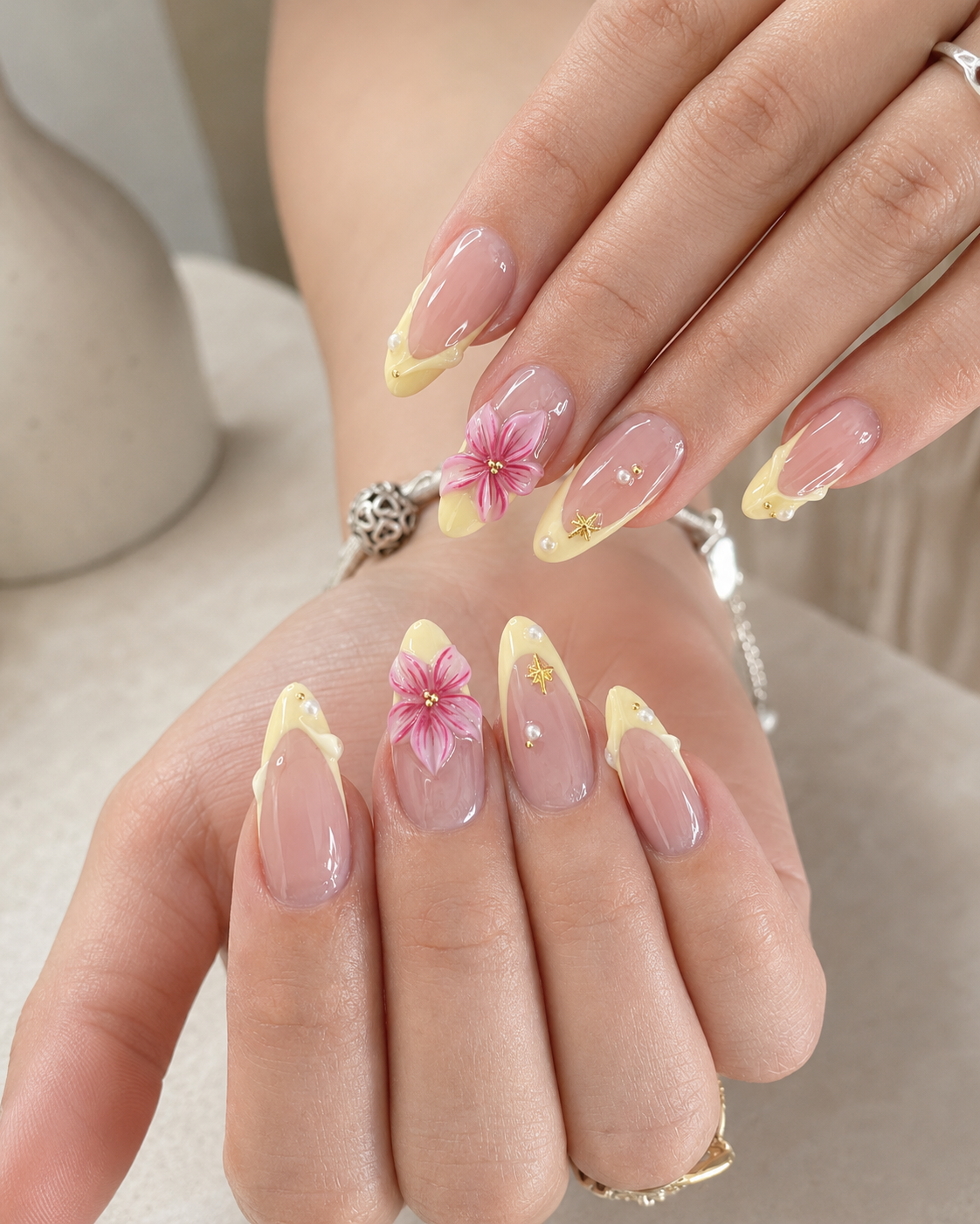 7 Flower Nail Designs for a Fresh, Feminine Manicure 5 A pink floral French manicure with soft yellow tips and delicate flower accents.
Alt text: Pink flower nail design with glossy nude bases, pale yellow French tips, and soft pink floral nail art. This feminine floral manicure is perfect for flower nails, pink flower nails, elegant flower nail designs, and romantic floral nail inspiration.