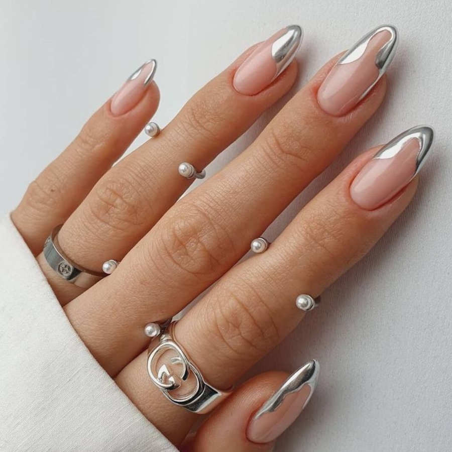 High-shine chrome French manicure with metallic silver tips on elegant almond nude nails.