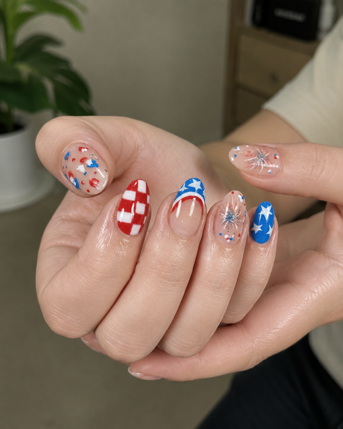 Patriotic fireworks nail design with red, white, and blue stars, glitter bursts, and festive Independence Day nail art.