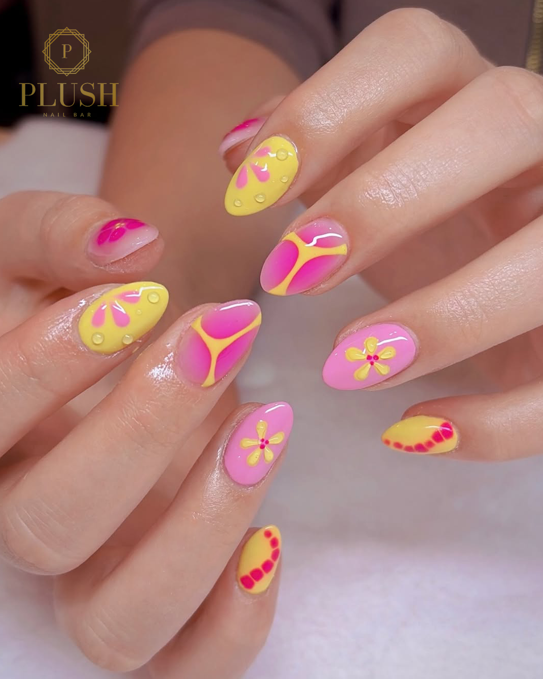 Spring Break Bliss: 4 Stunning Floral Nail Ideas That Will Instantly Elevate Your Vacation Look 3 Bright pink and yellow Spring break nails with playful floral designs, glossy finish, and bold color-block patterns.