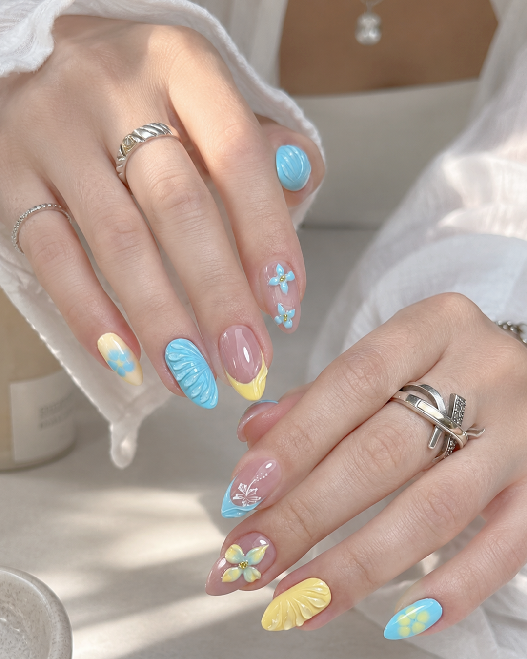 7 Flower Nail Designs for a Fresh, Feminine Manicure 2 A pastel garden flower nail designs with soft blue, yellow, and pink details for a fresh seasonal look.
Alt text: Pastel flower nail design featuring soft blue, yellow, and pink accents with delicate floral nail art. This colorful floral manicure is ideal for spring flower nails, summer flower nails, pastel floral nails, cute flower nails, and fresh flower nail designs.