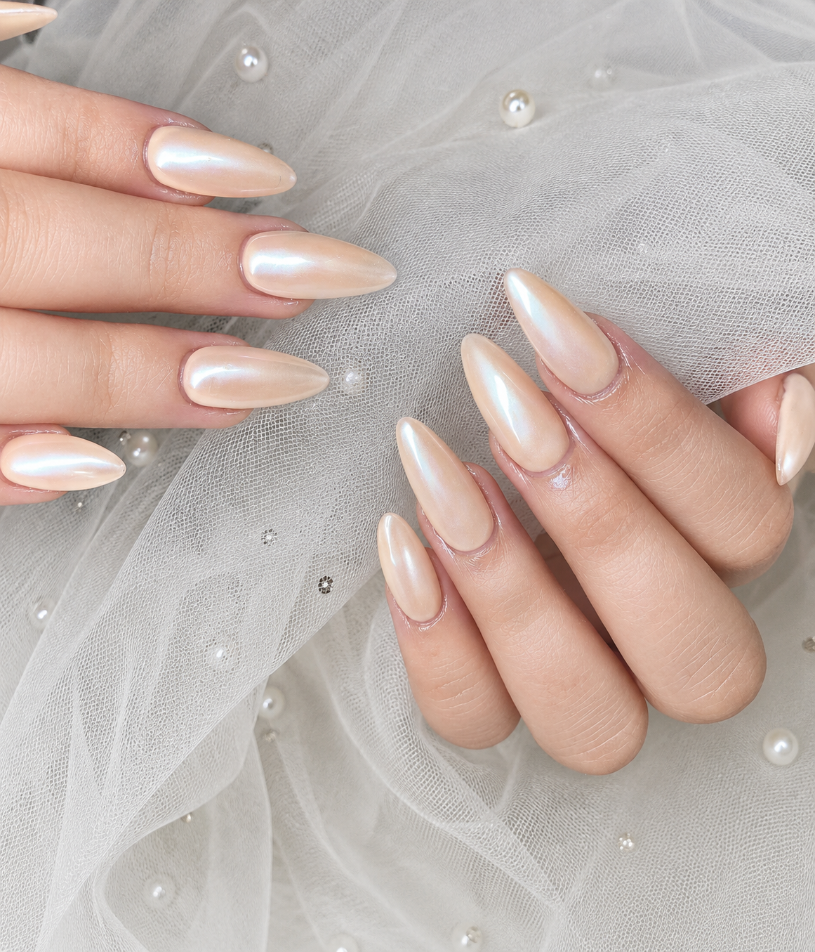 Champagne Chrome Nails with an iridescent pearl chrome finish on long almond nails, offering a luminous bridal-inspired manicure with a soft glow.
