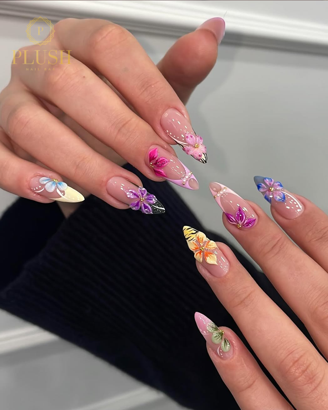 Spring Break Bliss: 4 Stunning Floral Nail Ideas That Will Instantly Elevate Your Vacation Look 2 Colorful Spring break floral nails featuring hand-painted tropical flowers on a nude base with vibrant purple, blue, pink, and yellow accents.