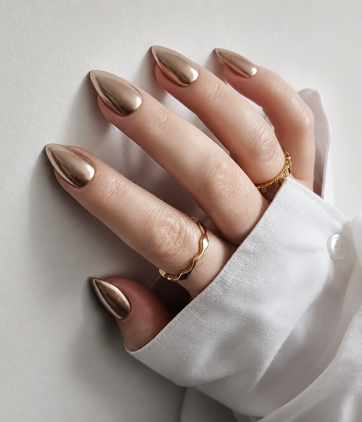 Champagne Gold Mirror Chrome Nails featuring a smooth reflective metallic finish on almond nails for an expensive-looking neutral manicure.