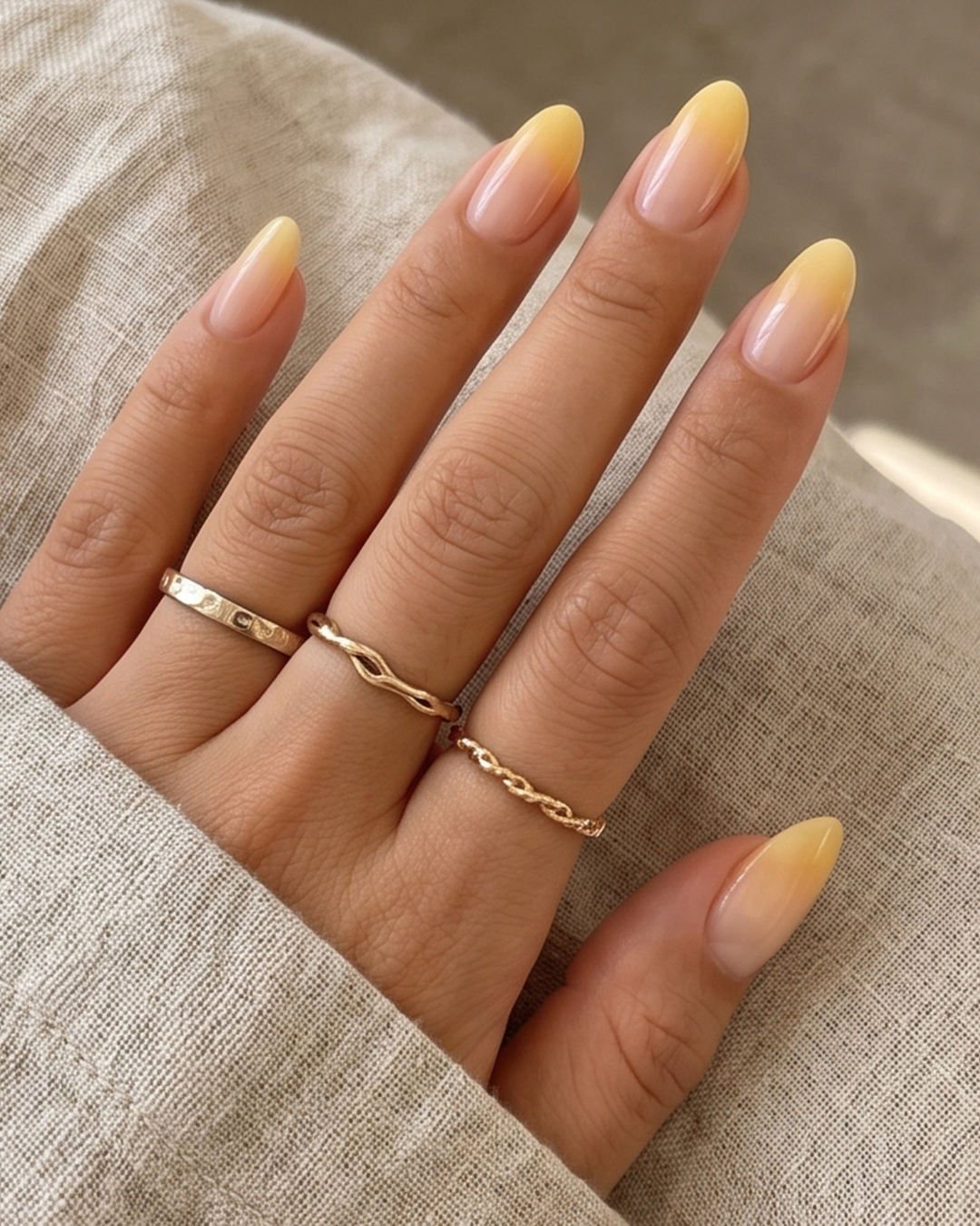 Butter yellow ombré nails with a soft nude-to-yellow gradient on almond-shaped nails.