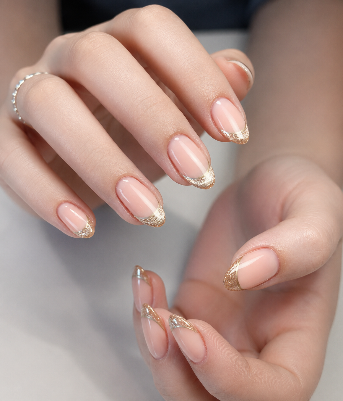Champagne Chrome Nails featuring glitter gold French tips on short almond nails, creating an elegant and timeless manicure for everyday luxury.