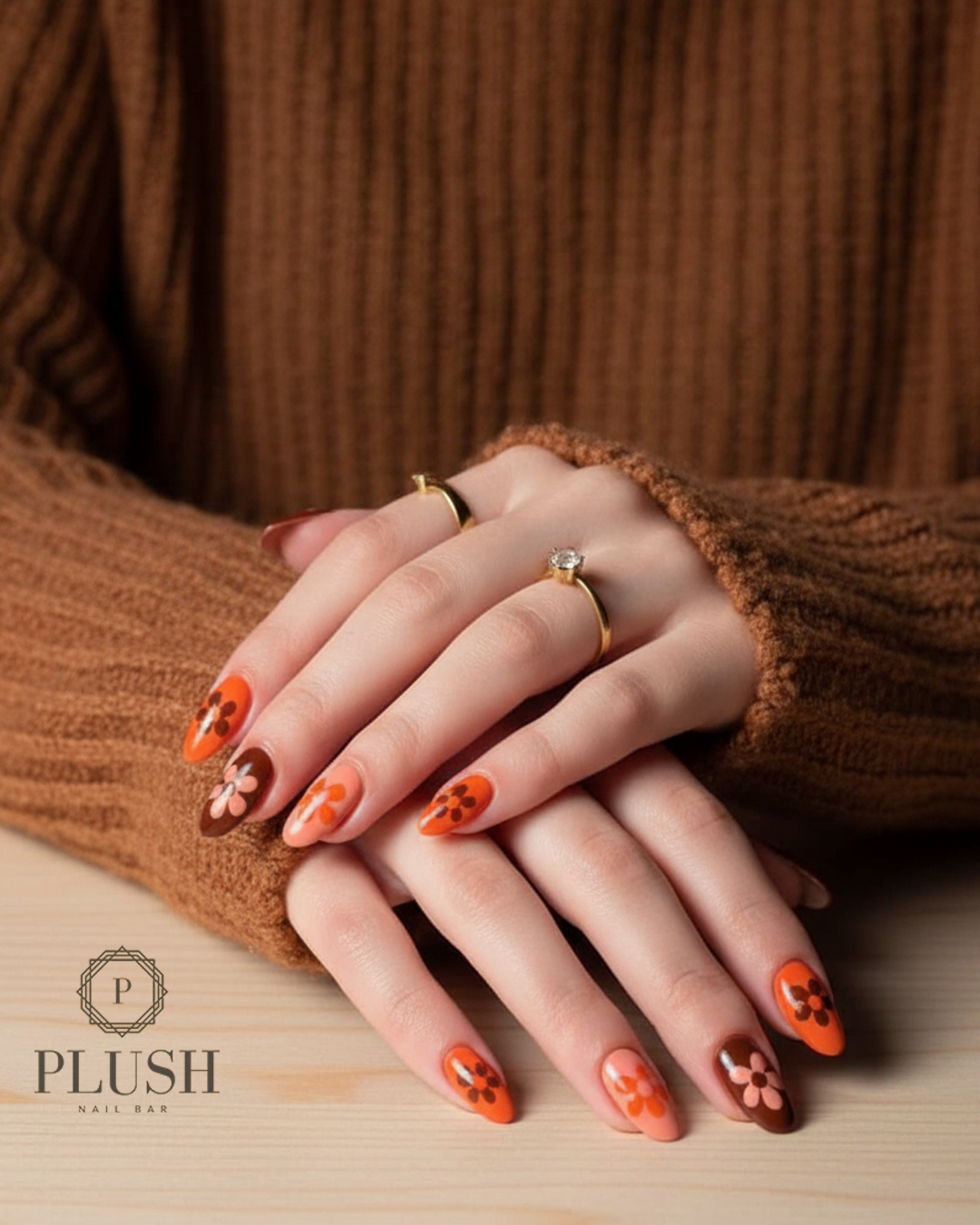 Retro-style orange and brown floral nails, ideal for a cheerful Thanksgiving manicure.