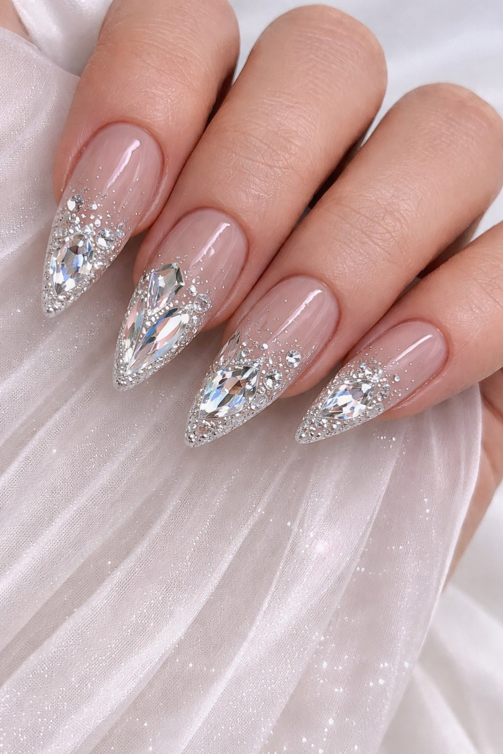 Viral Glass Skin effect Crystal Nails and intricate 3D large rhinestone placement at Plush Nail Bar Houston. Sleek almond shape with custom diamond-style cluster artistry on a high-gloss nude