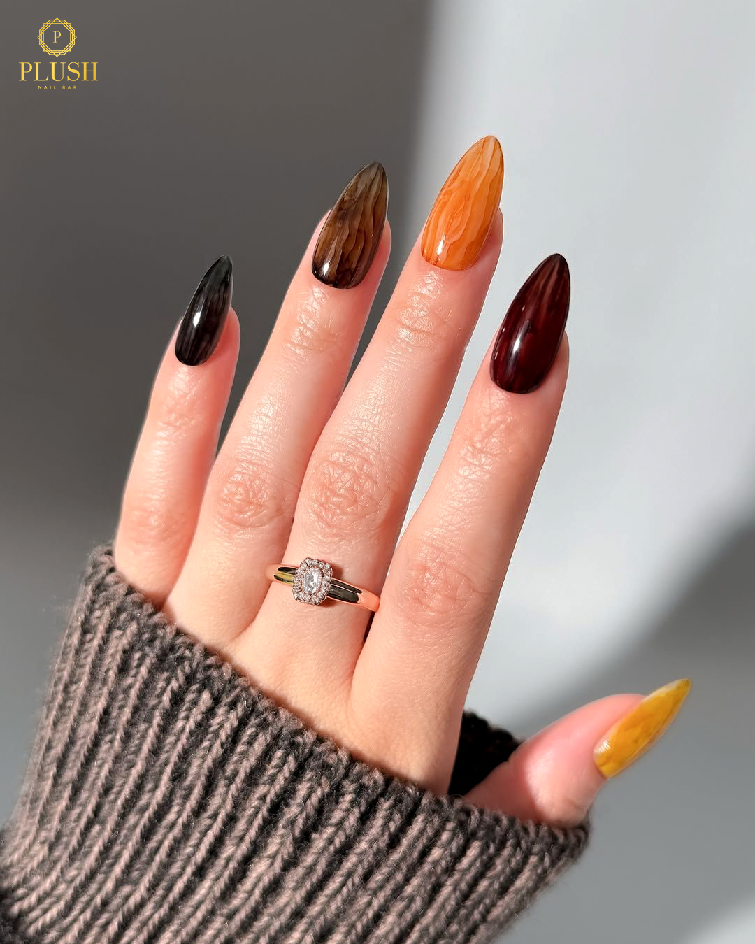Thanksgiving-themed marble nails blending mocha, honey, and cranberry shades for a cozy autumn vibe.