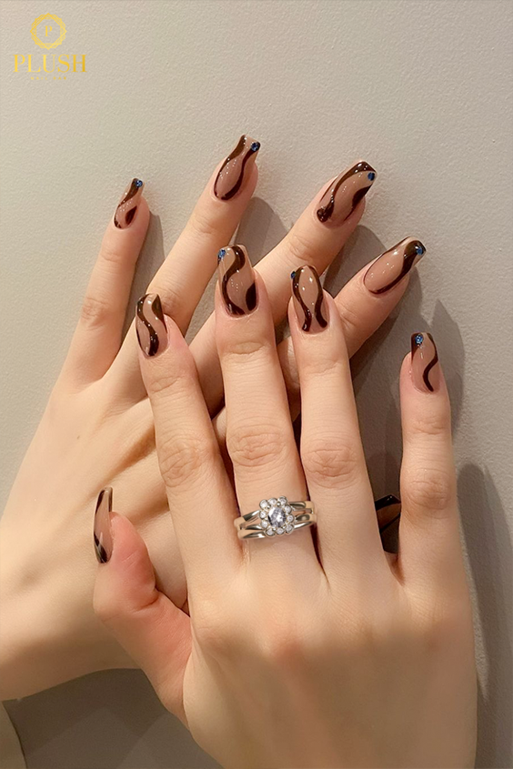 10+ Brown Nail Ideas for a Chic Autumn Look 4 Glossy brown swirl nail art in rich chocolate tones with subtle accent dots, fall 2025 trend.