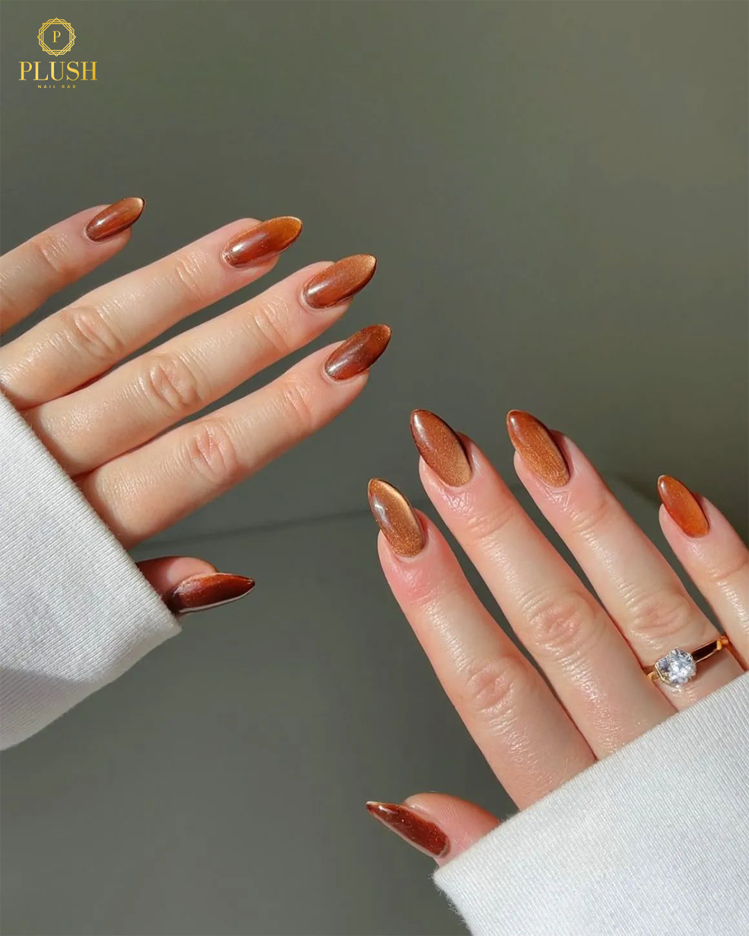 10+ Brown Nail Ideas for a Chic Autumn Look 6 Shimmery cinnamon brown cat-eye nails with metallic finish, almond-shaped fall manicure.