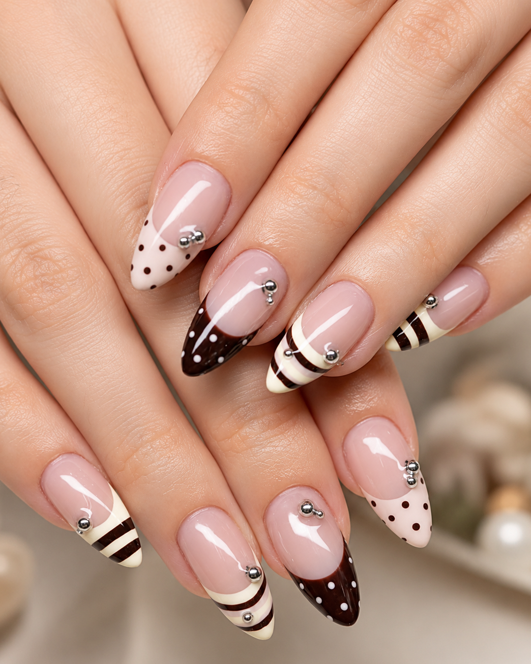 Chocolate brown polka dot and striped French nails with silver studs