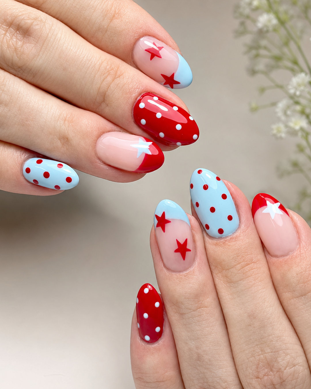 Red and blue polka dot nails with star accents and colorful French tips
