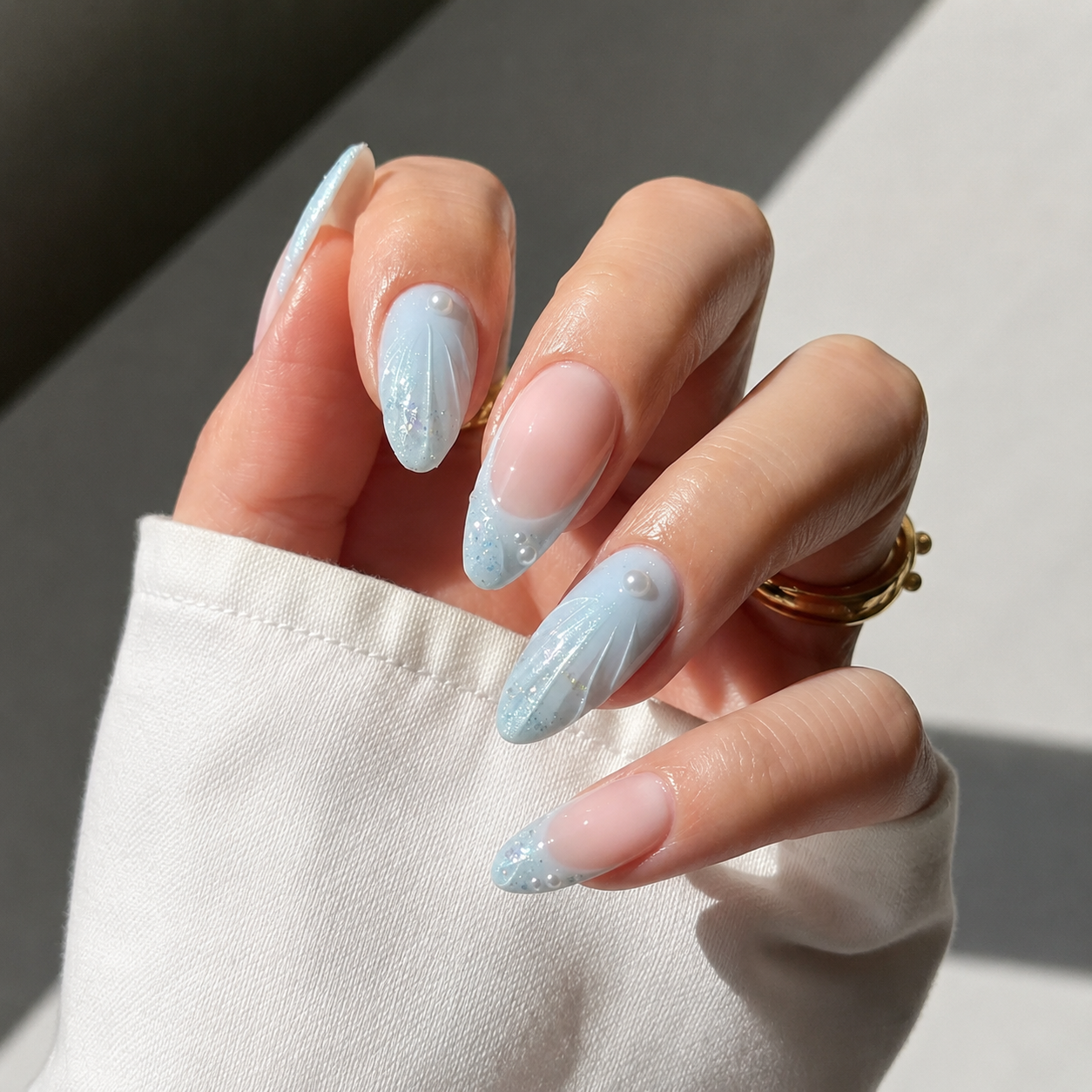 Blue mermaid nails with pearl accents and seashell texture.