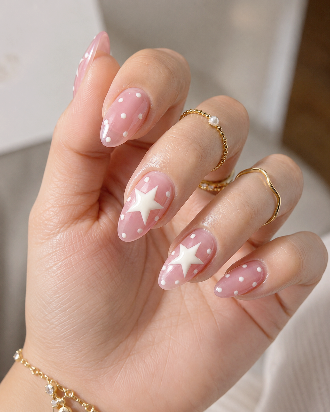 Pink nails featuring cute white star nail art.