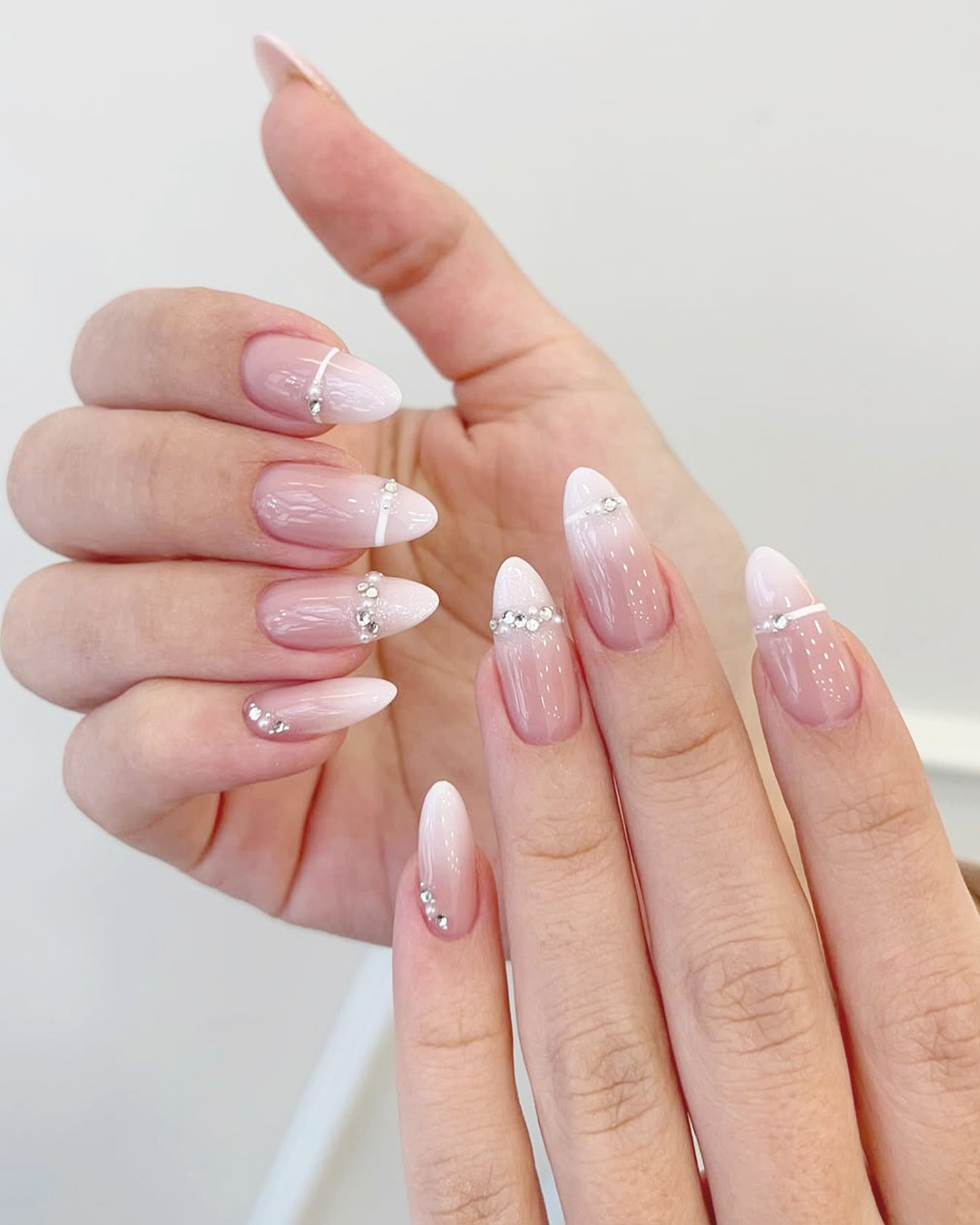 soft pink wedding nails with glitter ombre and french tip, elegant almond shape bridal nails