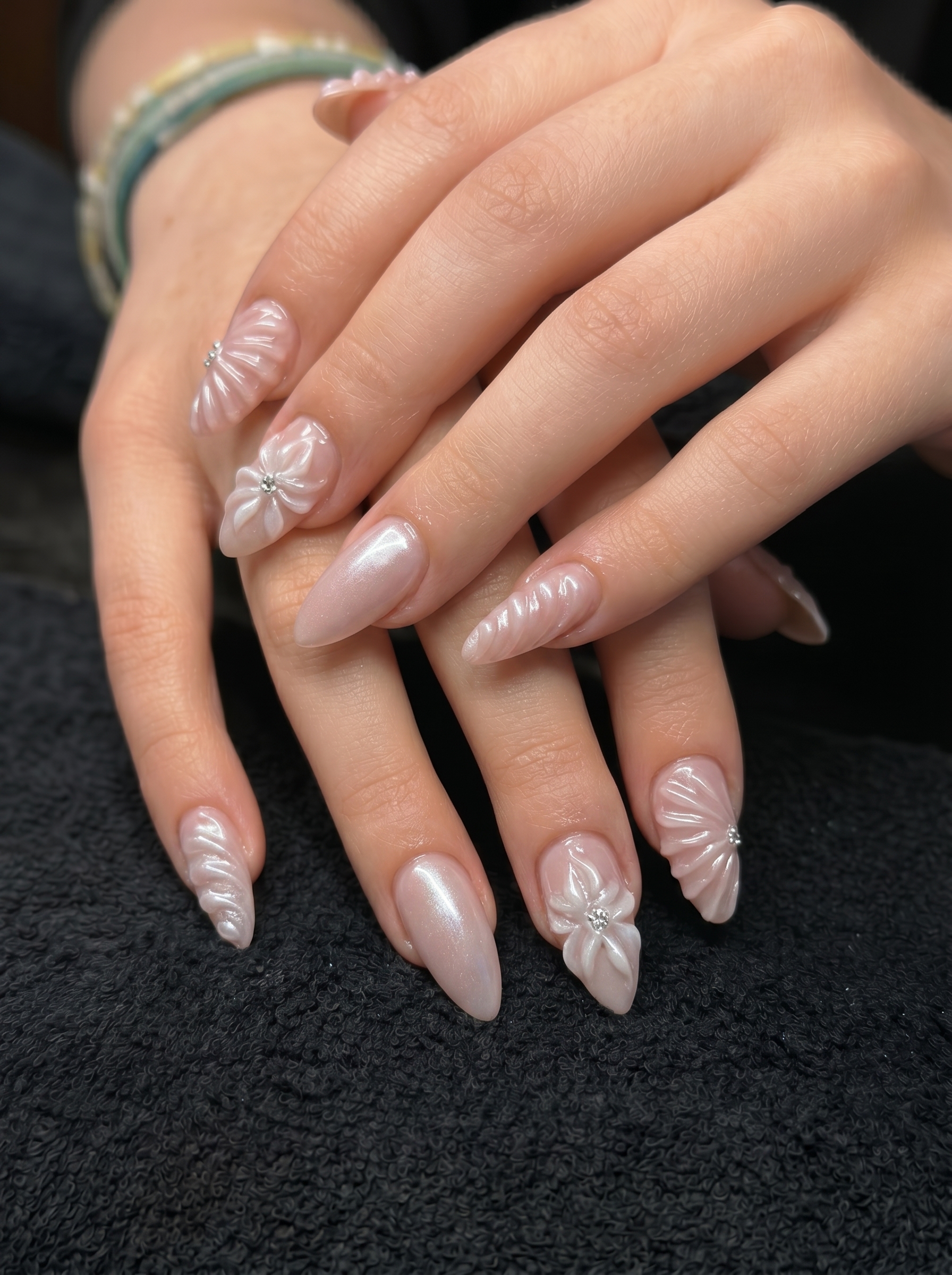 White Chrome Nails: The Stunning Trend Everyone Is Wearing in 2026 1 Elegant 3D pearl white chrome nails with sculpted floral nail art on almond-shaped nails.