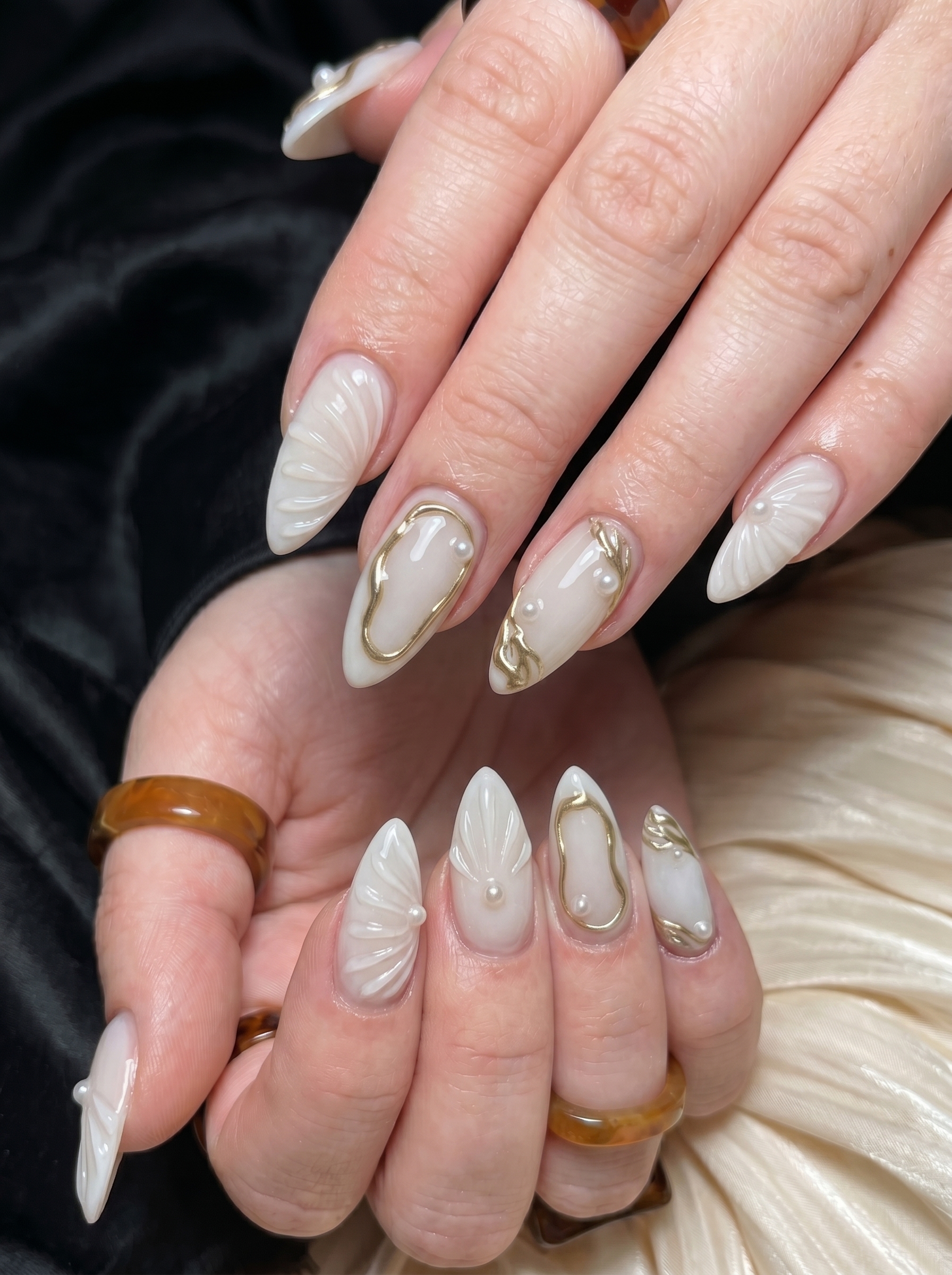 White Chrome Nails: The Stunning Trend Everyone Is Wearing in 2026 5 White chrome nails with gold abstract details, 3D shell accents, and pearl embellishments.