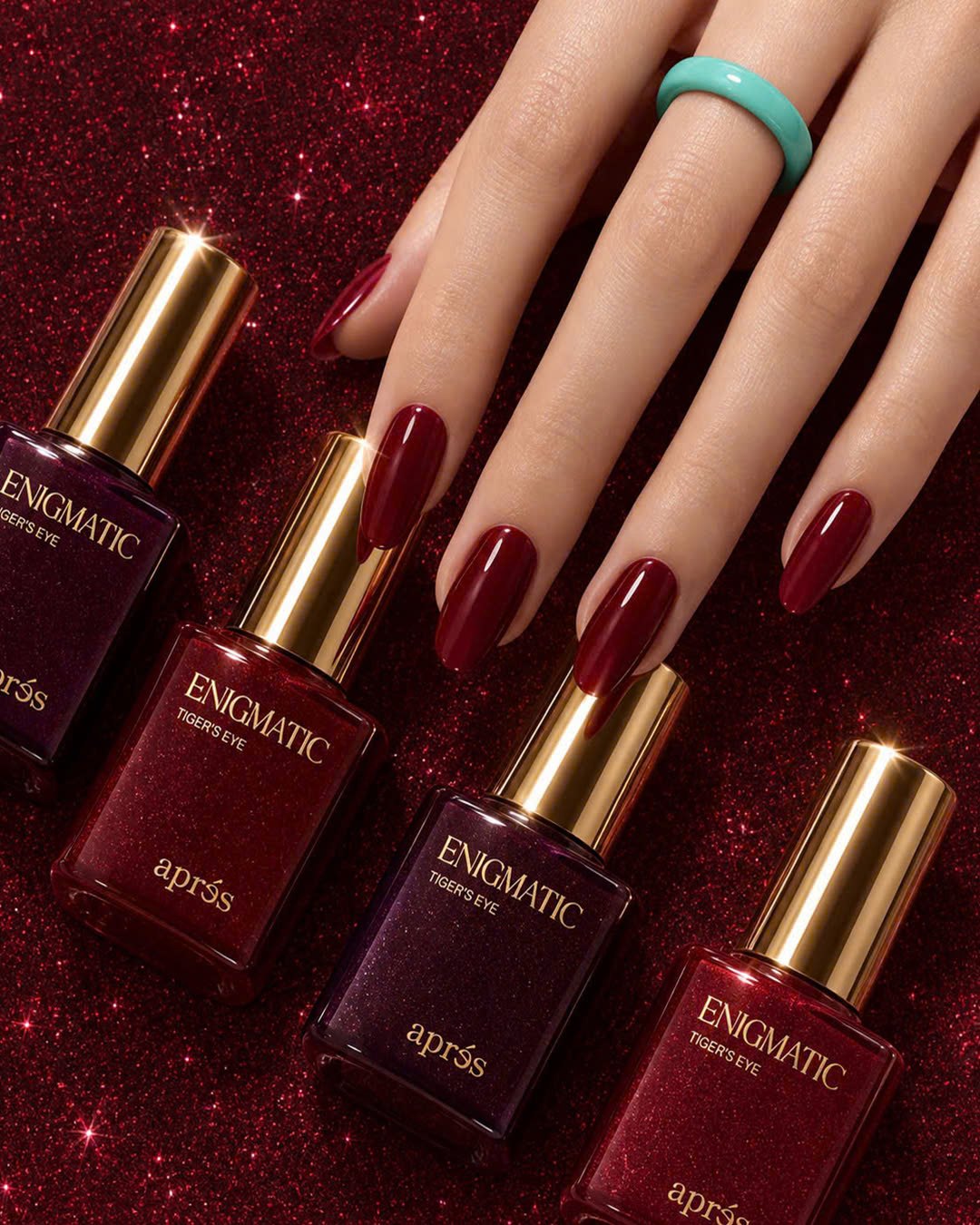 HEMA-Free Gel Manicure: Meet the Apres Upgrade at Plush Nail Bar 3 Glossy deep red almond nails beside Apres Enigmatic gel polish bottles on red glitter