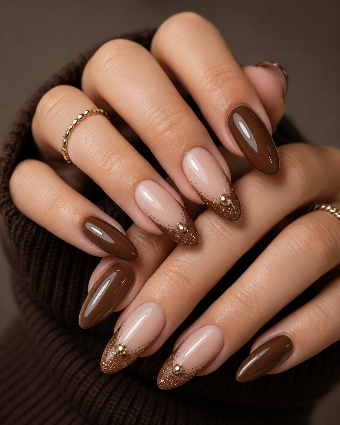 Thanksgiving Nails 2026: Simple, Warm Sets for the Holiday 1 Almond nails alternating glossy chocolate brown and nude with bronze glitter V French tips and gold beads