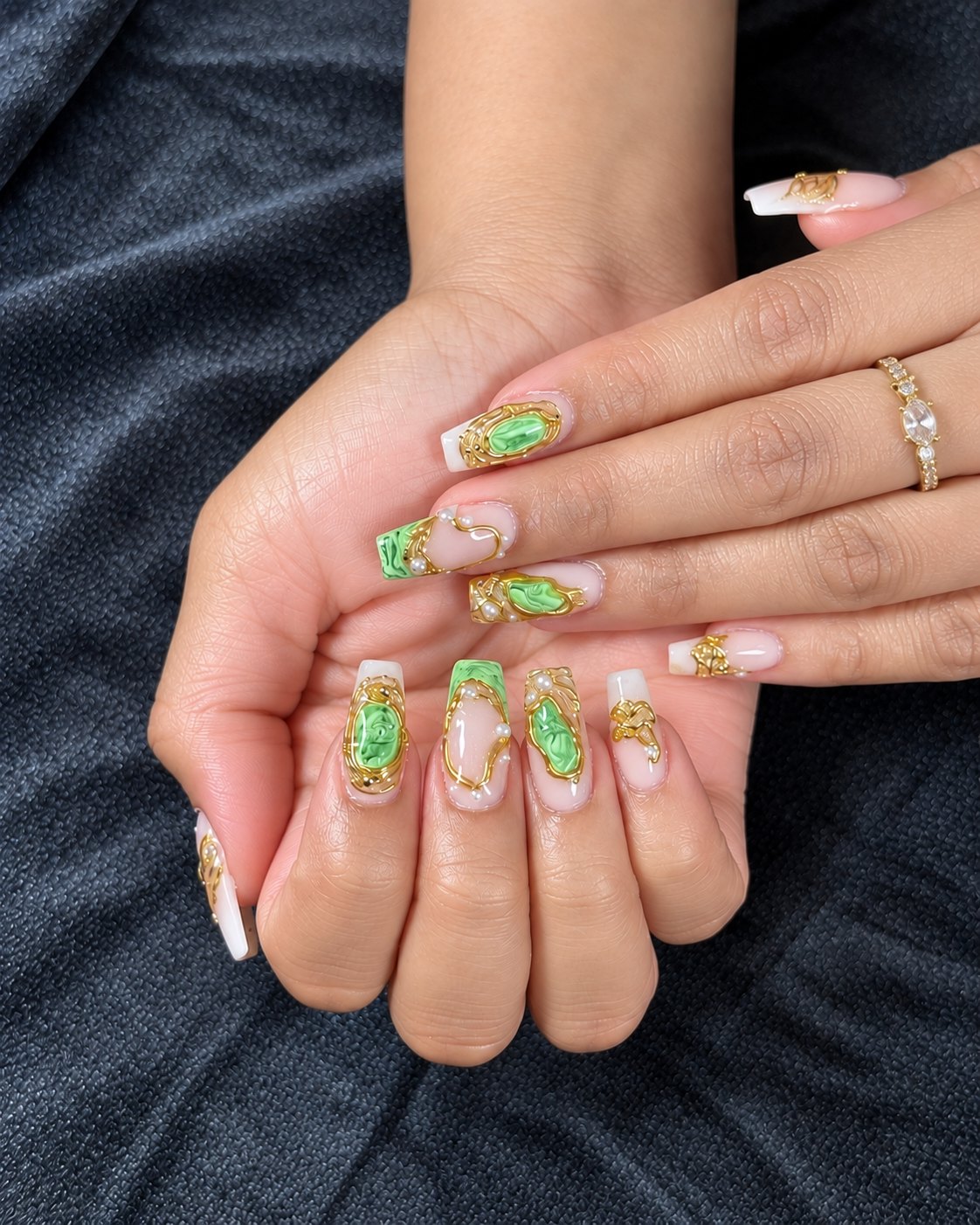 Long coffin nails in milky white with jade green marbling and raised gold filigree