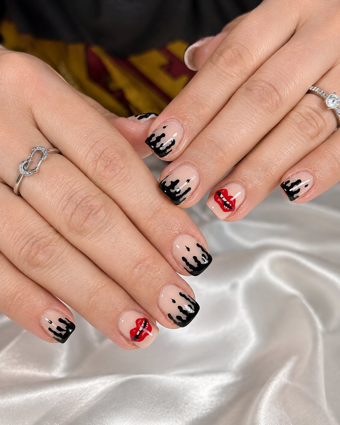 Short square nude nails with dripping black French tips and red lips accent nails