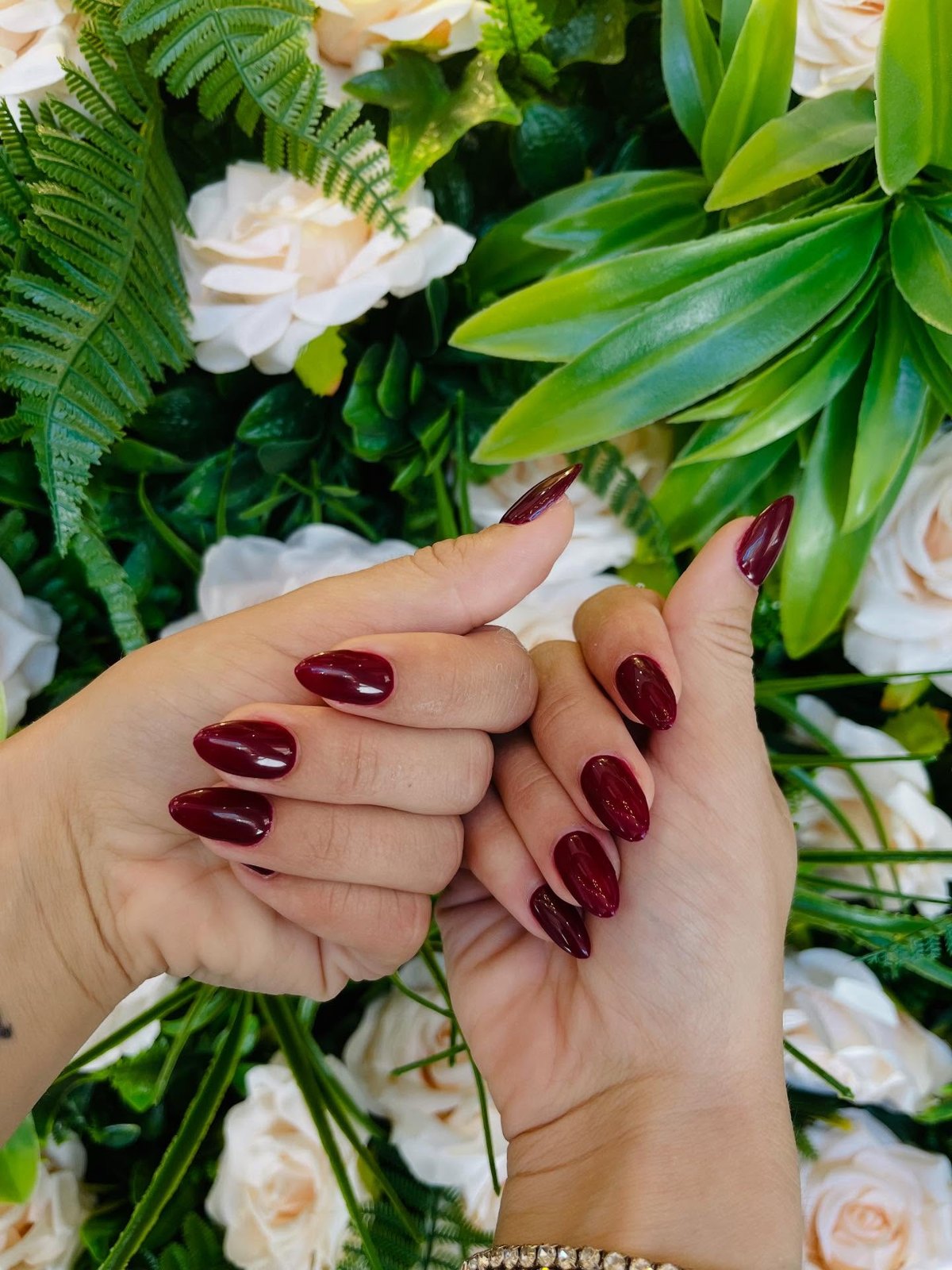 Almond nails in deep oxblood burgundy with a subtle shimmer and no nail art