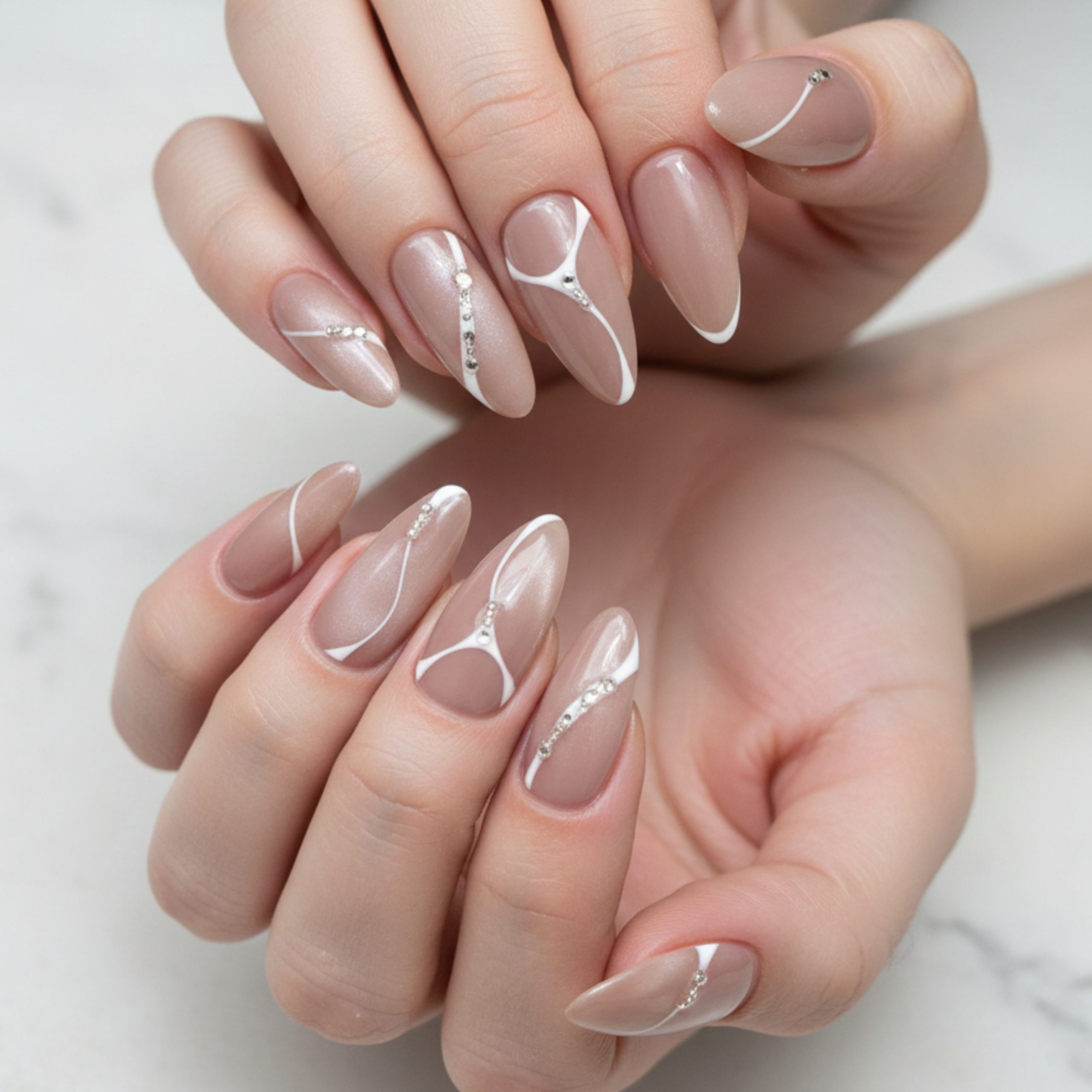 Minimalist homecoming nails featuring a nude base, white abstract line art, and subtle rhinestone accents on almond-shaped nails.