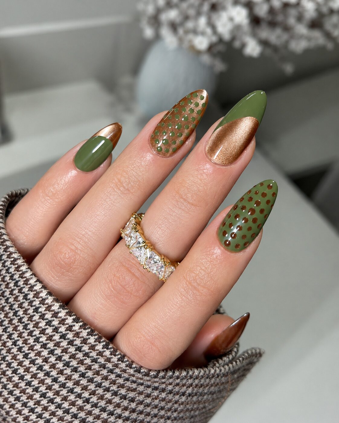 Olive and copper cat-eye almond nails with polka dots and a diagonal tip