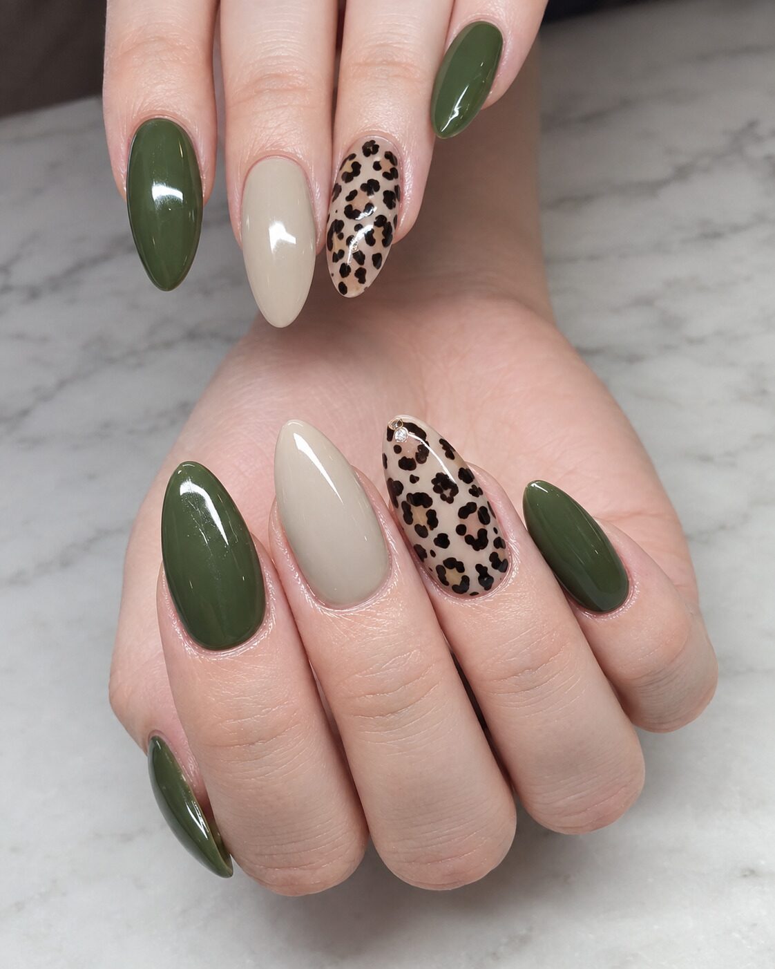 Deep olive almond nails with a latte beige nail and leopard print accents