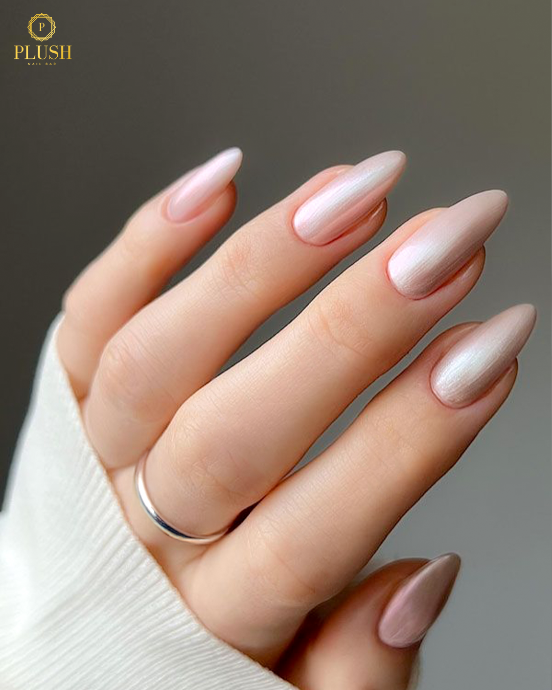 Metallic silver chrome almond nails decorated with small pearl accents for a luxurious look.