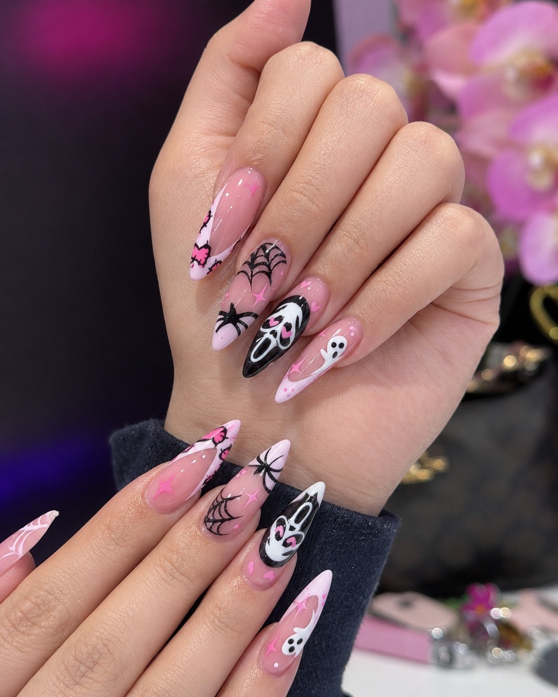 Pink Halloween stiletto nails with heart-eyed Ghostface masks, spiders, ghosts and pink bows