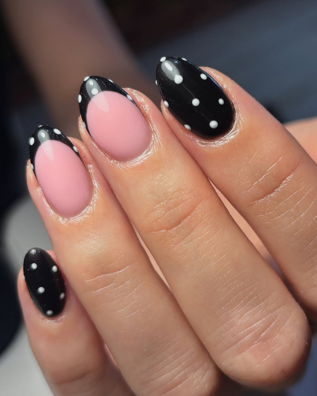 Polka dot nails combining black and pink polish with bold white dots in a striking monochrome design.