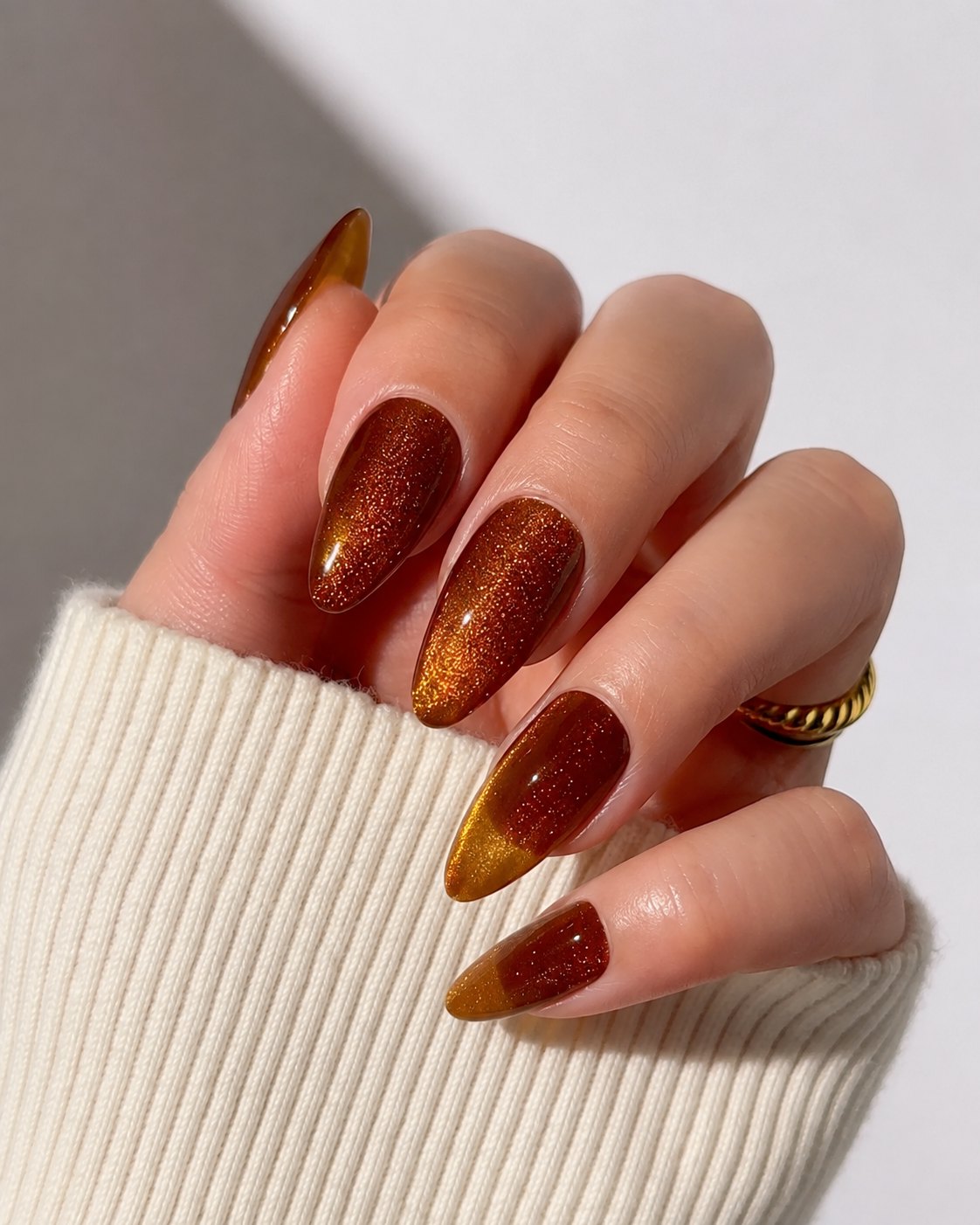 Amber glass cat-eye nails in burnt sienna with a gold light band