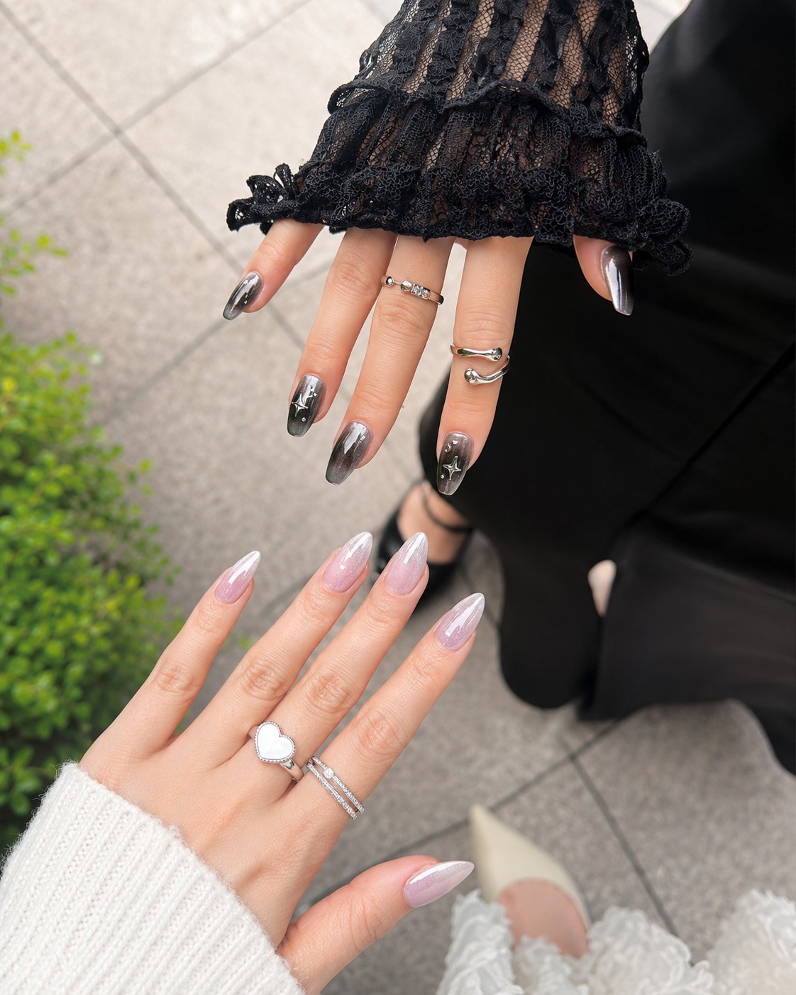 Black chrome smoke ombre nails beside pearl white chrome nails