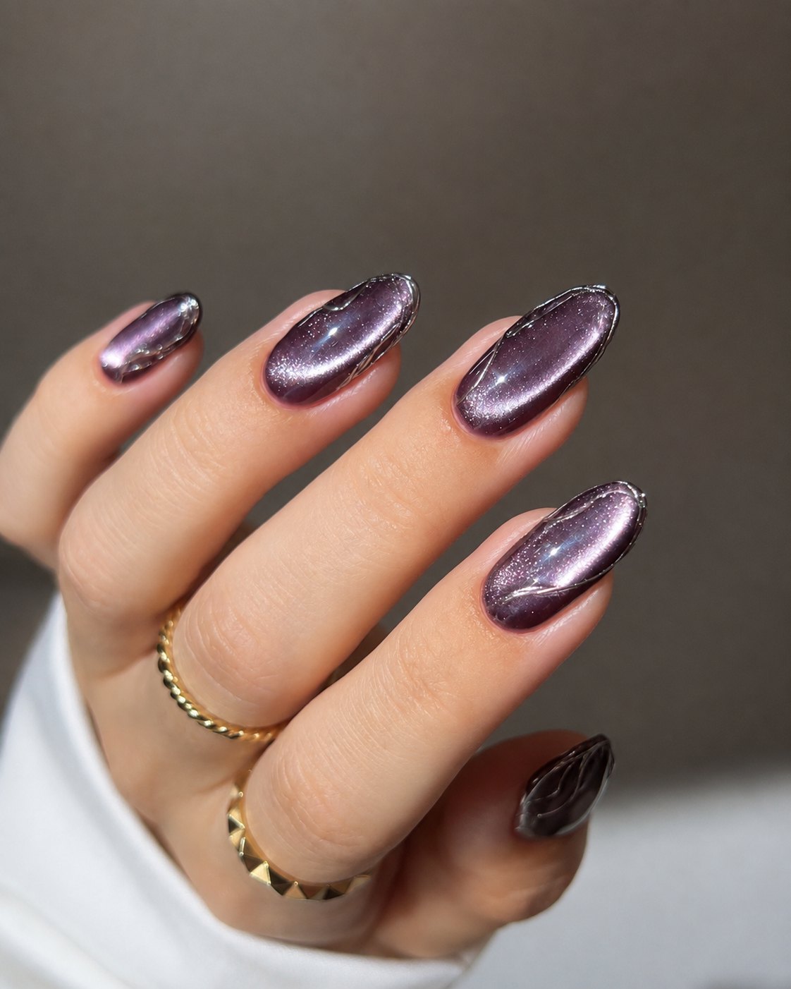 Plum mauve cat-eye nails with a smoked outline around each nail