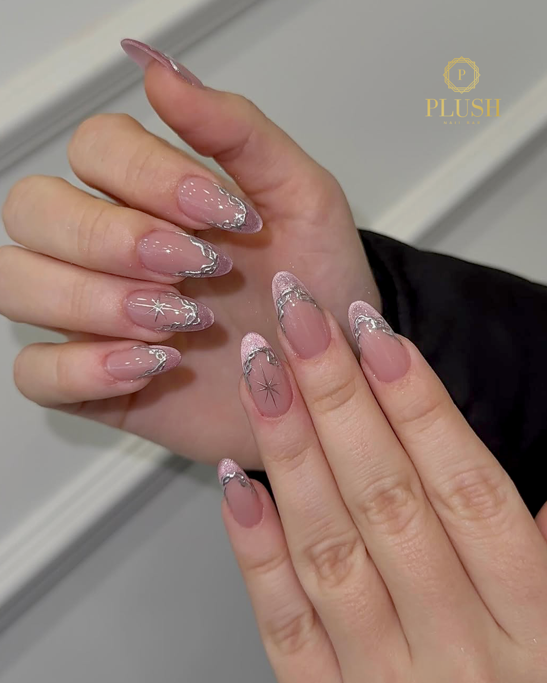 Shimmer pink valentine nails with silver French tips and star accents at Plush Nail Bar